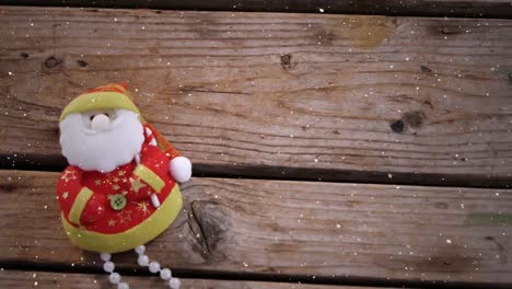 Video-composition-with-falling-snow-over-desk-with--santa-doll