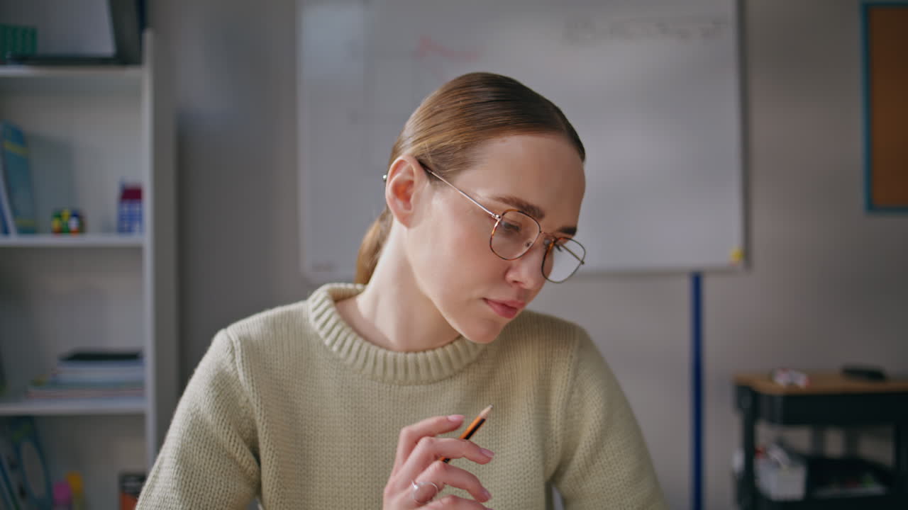 Smart woman working school closeup. Young teacher in glasses checking homework