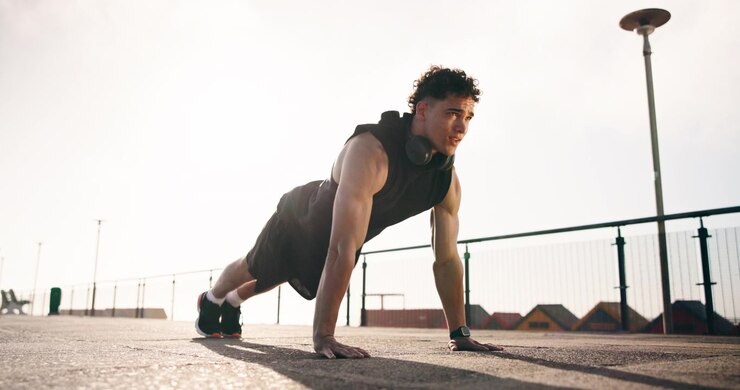Young Man Doing Pushups Outdoors During Workout