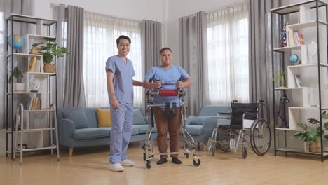 아시안 남성 간호사와 환자의 몸이 가득 차 있으며, 집에서 물리 치료를 하는 동안 카메라에 서서 미소 짓고 있습니다.
