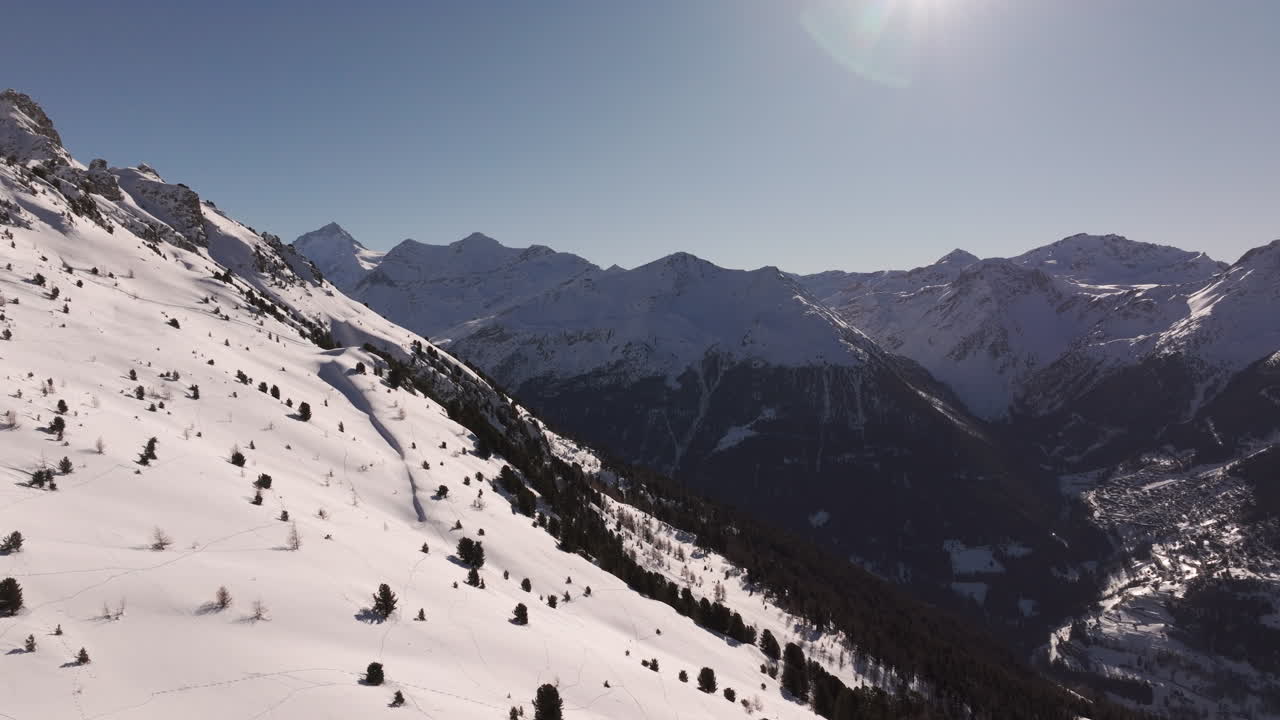 Ripresa aerea con drone dell'Hotel Weisshorn, Svizzera. Iconico hotel alpino circondato da cime innevate e foreste, che offre un paesaggio montano mozzafiato per viaggi, turismo e filmati video in stock cinematografici