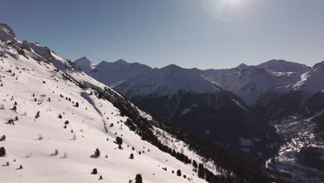 Drone aerial of Hotel Weisshorn, Switzerland. Iconic alpine hotel surrounded by snowy peaks and forests, offering breathtaking mountain scenery for travel, tourism and cinematic stock footage