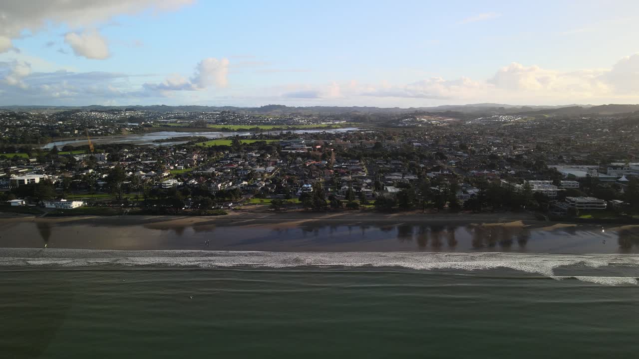 alejándose del atardecer en la playa de orewa, nueva zelanda