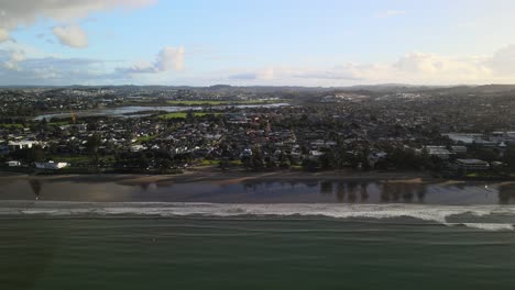 Alejándose-Del-Atardecer-En-La-Playa-De-Orewa,-Nueva-Zelanda