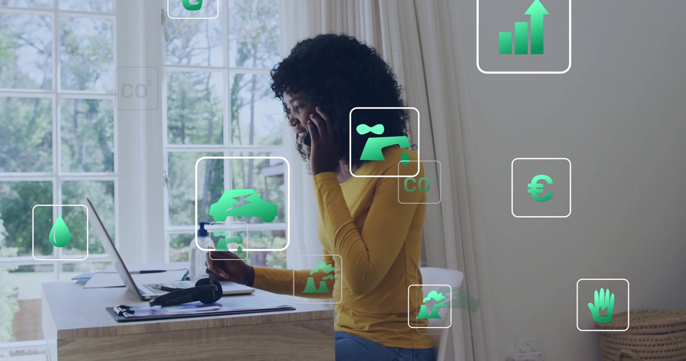 Woman taking phone call while tapping laptop and monitoring green utility icons floating around her