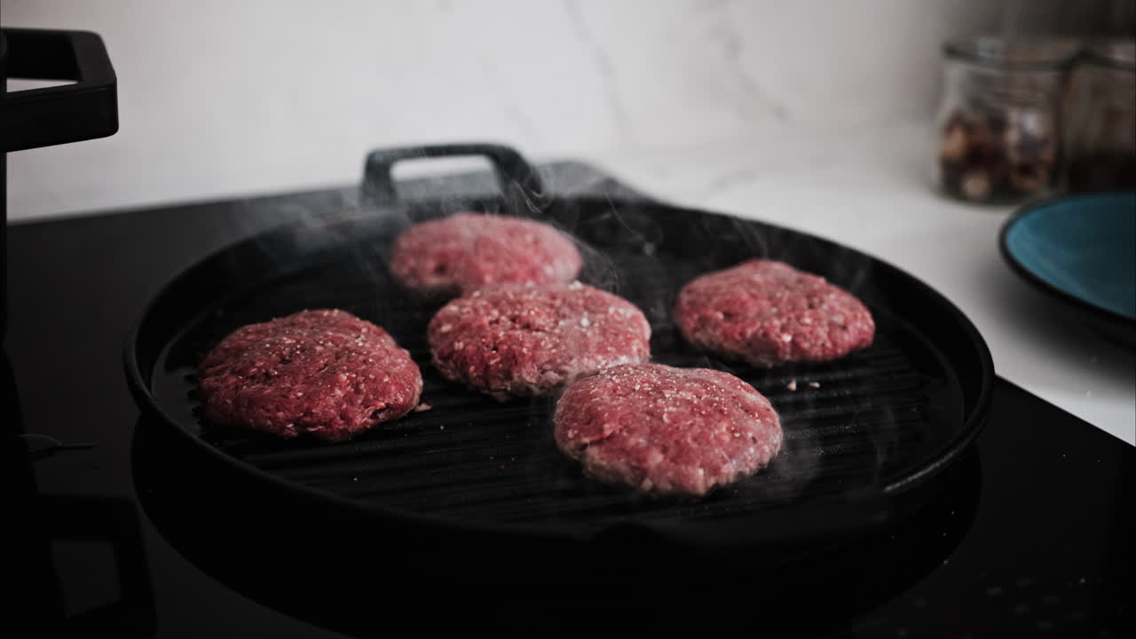 Burger patties being cooked on a grill pan