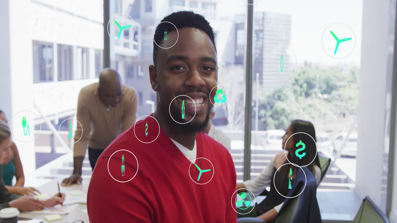 Animation of icons over african american businessman having meeting at office