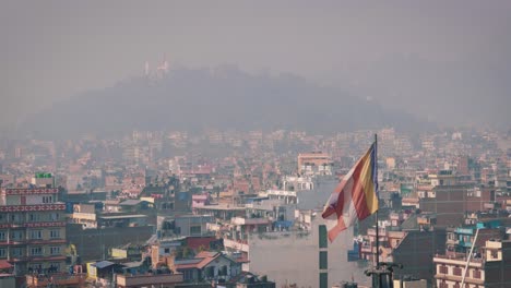 cityscape with a large number of buildings and structures with a flag at kathmandu, nepal- wide shot
