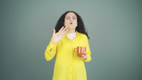 The young woman&#039;s mouth is burning from the hot drink.