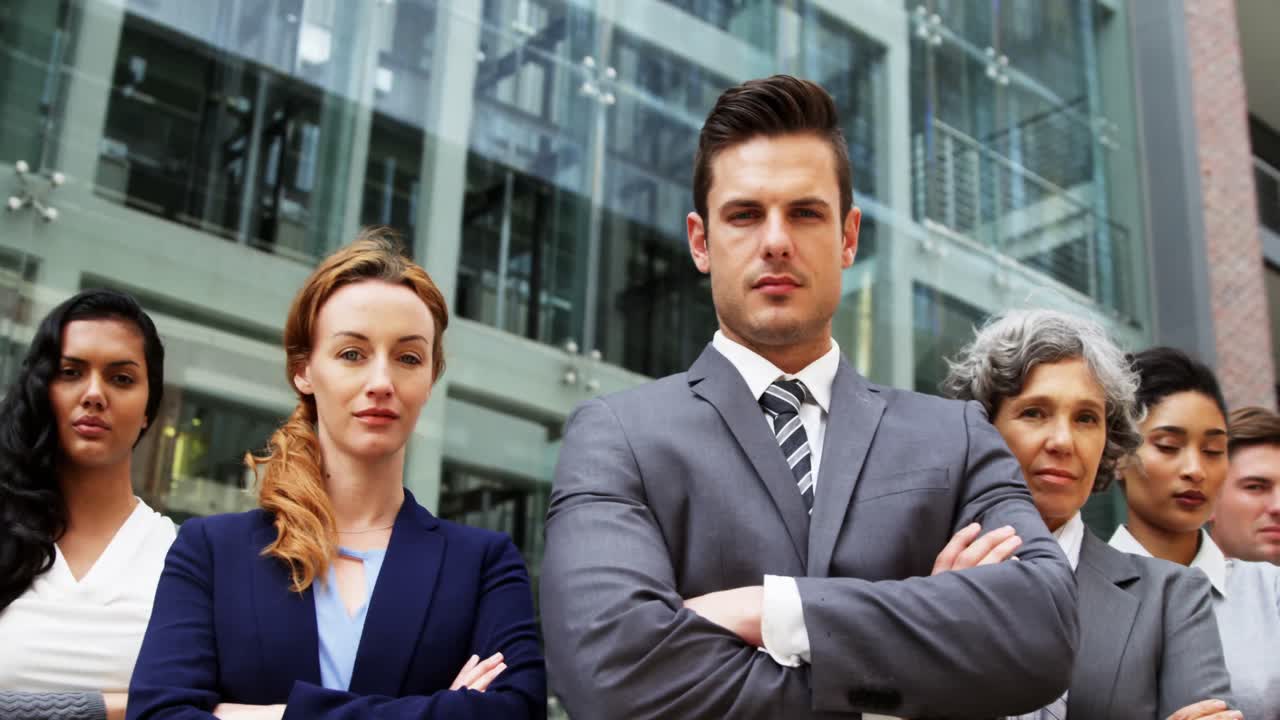 hombres de negocios de pie con los brazos cruzados en el edificio de oficinas