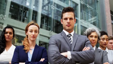 businesspeople standing with arms crossed in office building