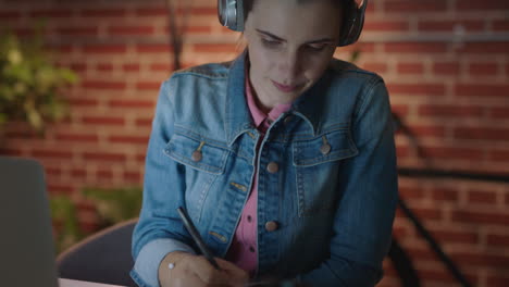 personas de negocios que trabajan hasta tarde en la fecha límite del proyecto mujeres empresarias que usan tabletas digitales escuchando música planeando estrategias escribiendo notas en la oficina por la noche