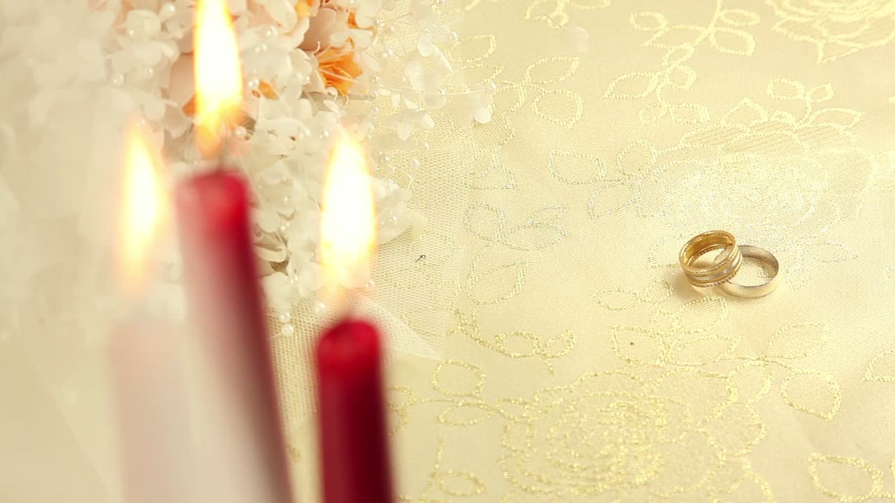 Обручальные кольца со свечами и цветами.