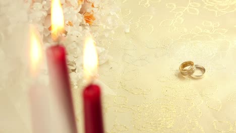 wedding rings with candles and flowers