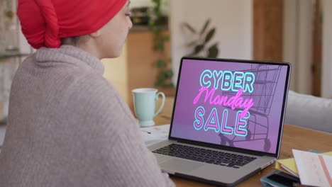 Biracial-Frau-Am-Tisch-Mit-Laptop,-Online-Shopping-Am-Cyber-Monday,-Zeitlupe