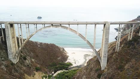 aerial static shot of bixby creek bridge and ocean in background, california