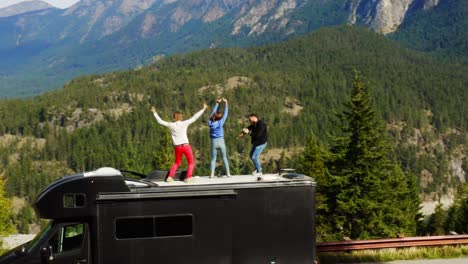 tourists dancing on edge of cliff with breathtaking view