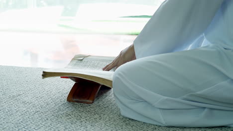 retrato de un musulmán asiático recitando el pasaje de surah al-fatiha del qur'an, en una oración diaria en casa en un solo acto de sujud llamado sajdah o postración