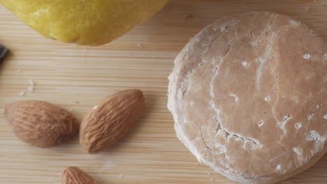 polvorón dulce tradicional español de navidad con almendras, chocolate oscuro, limón y un fondo de madera rústico.