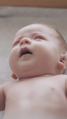 skilled pediatrician crosses and opens newborn baby arms making professional massage on changing table close view