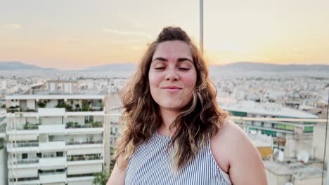 woman adjusts selfie stick for rooftop city vlog