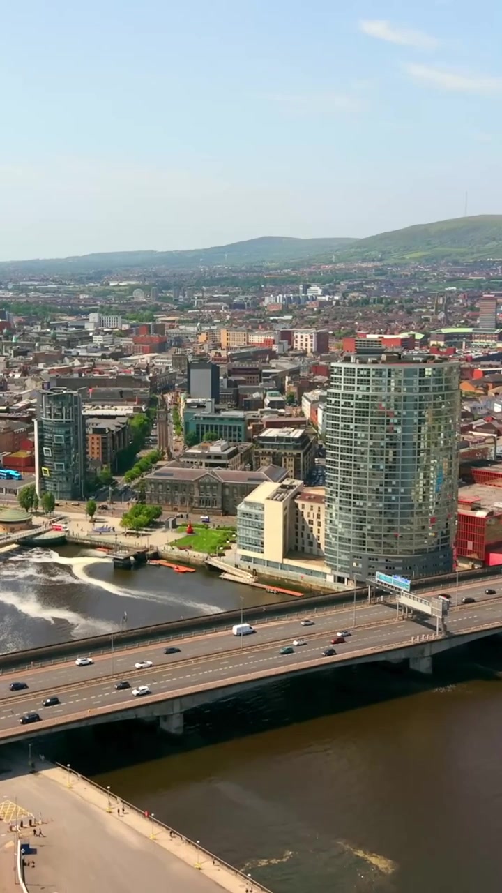 Vídeo aéreo em proporção vertical para redes sociais do centro da cidade de Belfast e do Rio Lagan no Condado de Antrim, Irlanda do Norte, no Reino Unido. Filmado em um dia de verão ensolarado em 1080x1920 e com cor Rec709