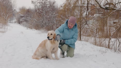 elderly woman and golden retriever in winter park