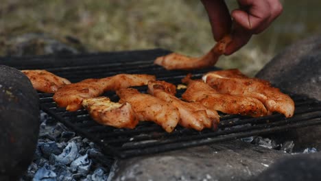 Colocando-Tiras-De-Pollo-Sazonadas-En-Una-Parrilla-Caliente-Usando-La-Mano