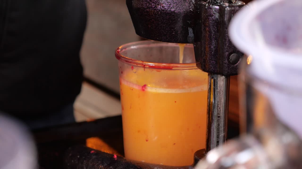 Succo d'arancia fresco in preparazione con uno spremiagrumi a manovella