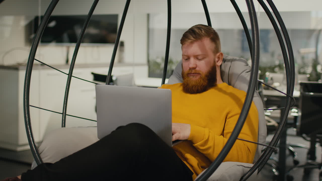 Man Working on Laptop in Hanging Chair