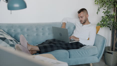 hombre trabajando desde casa en un sofá