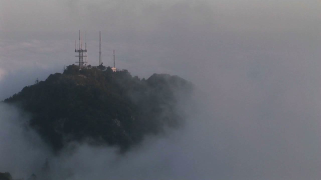 산꼭대기의 안테나 위로 무거운 구름이 덮힌 시간 경과