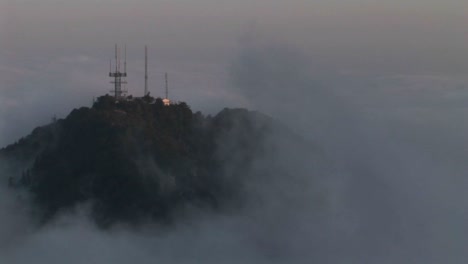un lapso de tiempo de una densa capa de nubes sobre antenas en la cima de una montaña