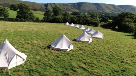 aerial filming of frontside luxury bell tents in welsh countryside, panning left to right