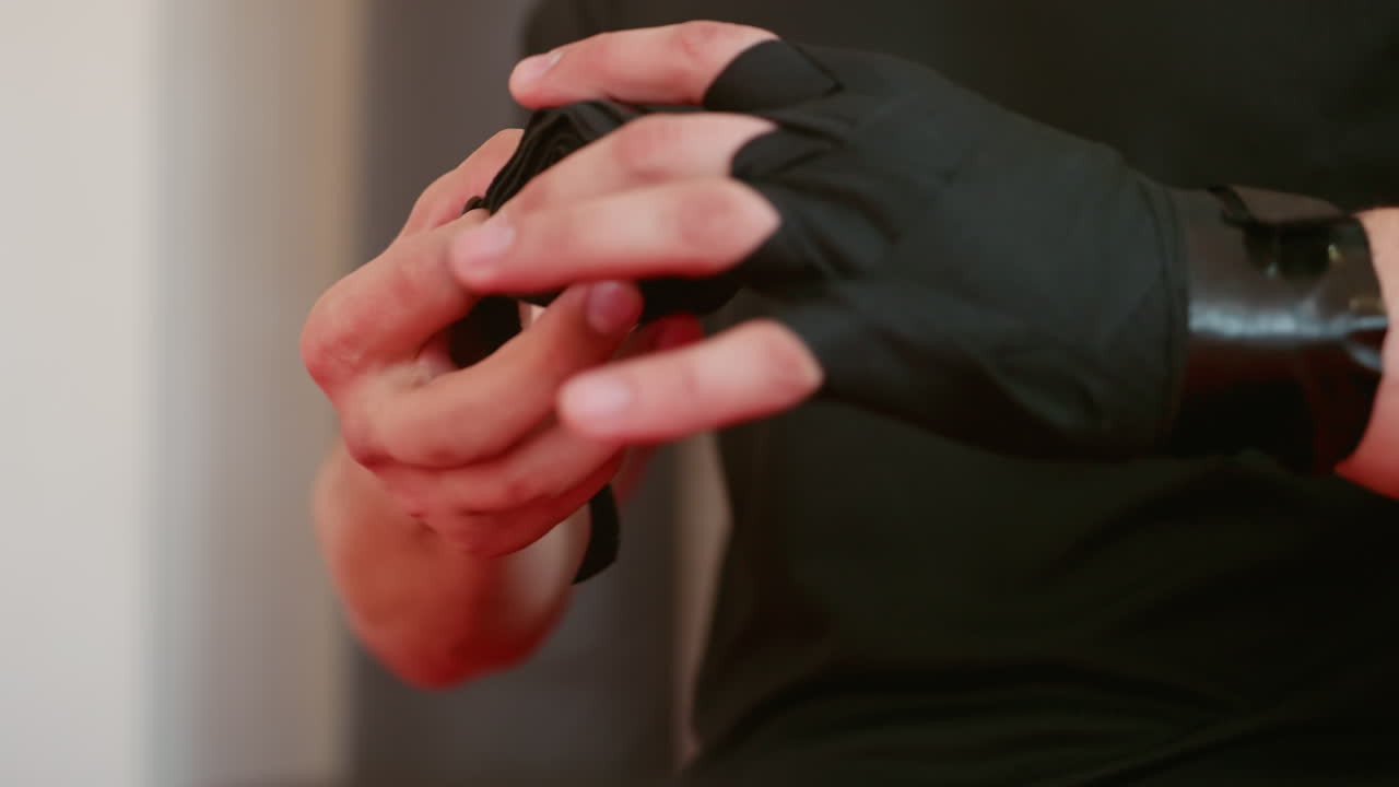 Athlete in black sportswear stands indoors under bright ceiling lights with serious expression, focusing with determination and mental strength, preparing for training session in gym environment