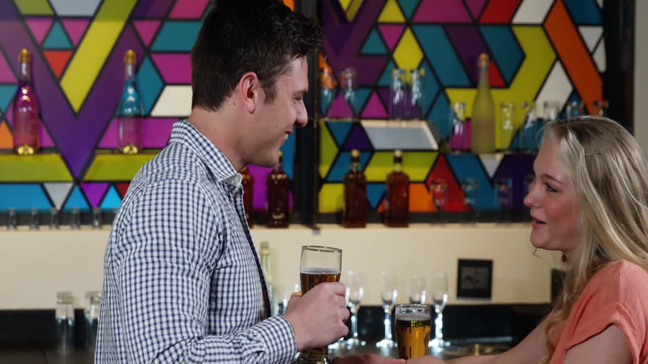 pareja interactuando entre sí mientras beben cerveza