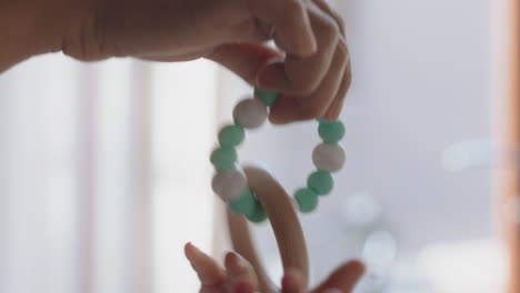 close-up-baby-hands-playing-with-toy-mother-calming-infant-enjoying-motherhood-playfully-caring-for-child-at-home