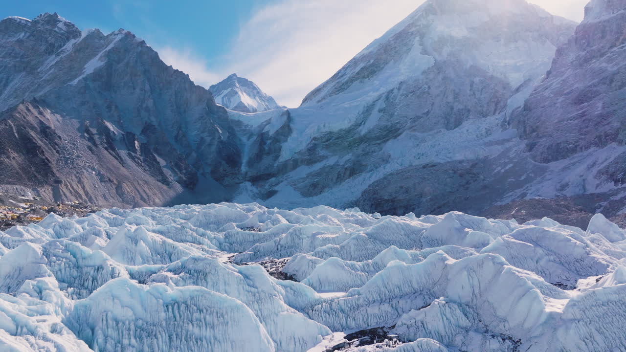 Drone shot of Khumbu Glacier at Everest Base Camp, showing melting ice, glacier, tents, snow capped mountains, global warming impact in Everest region of Nepal, Mountain climbers start climbing point
