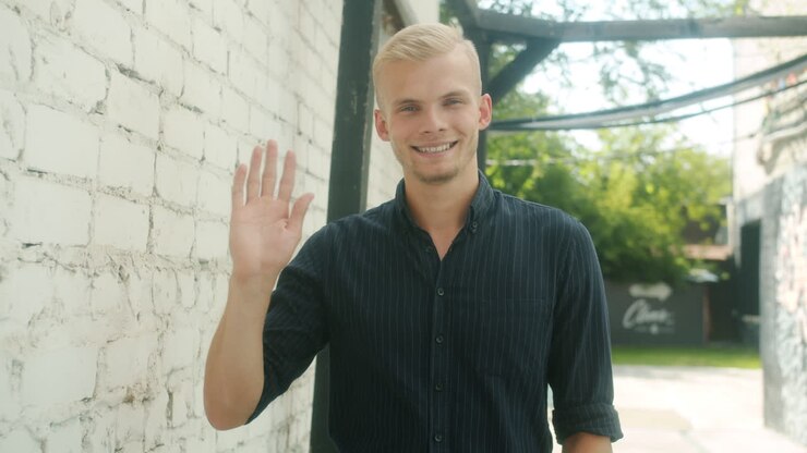 Friendly Young Man Waving Hello