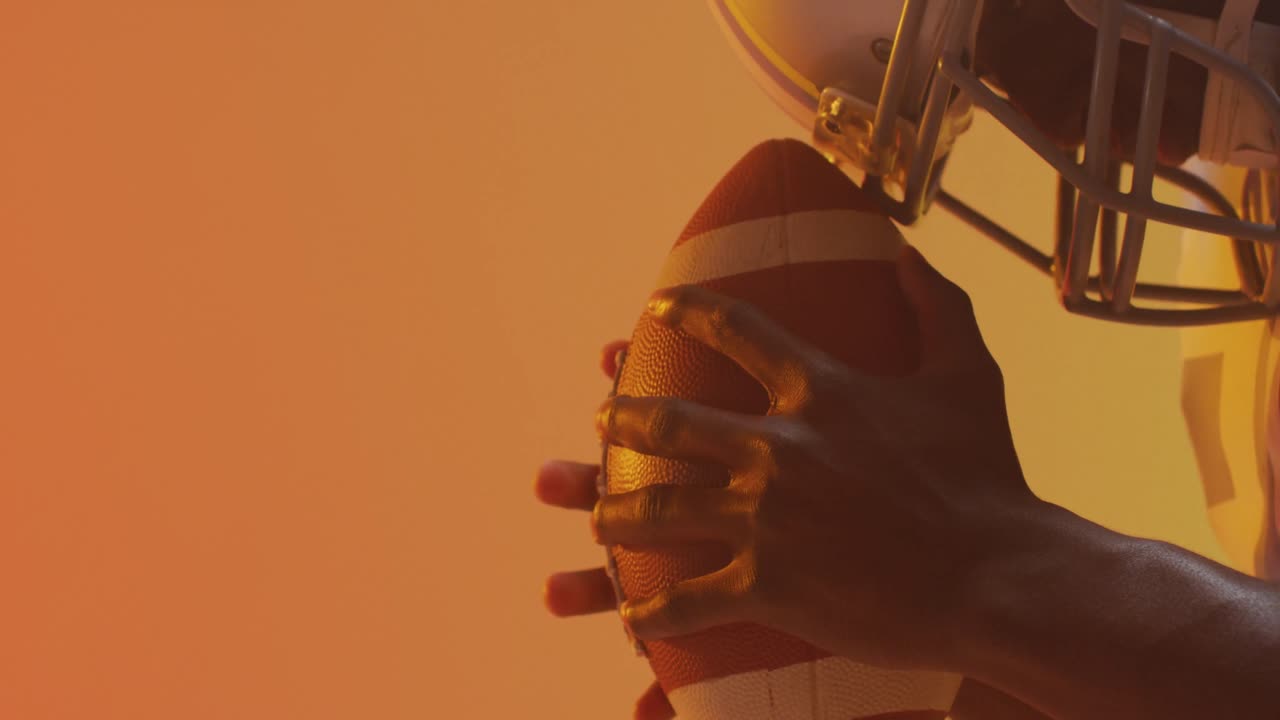 Video di giocatore di football americano afroamericano con il pallone su sfondo arancione