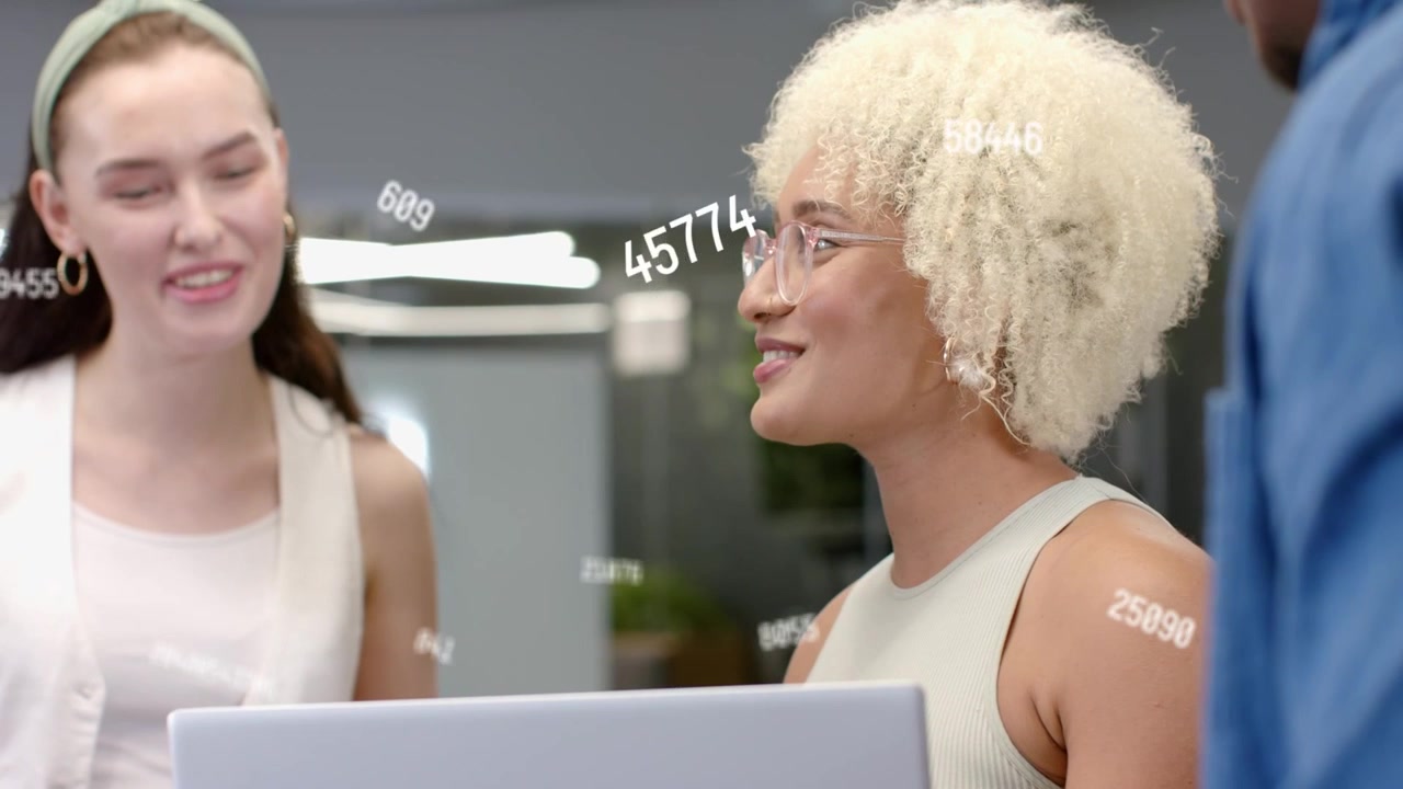 Seated woman looking up from laptop, making team laugh with data overlays animating for business