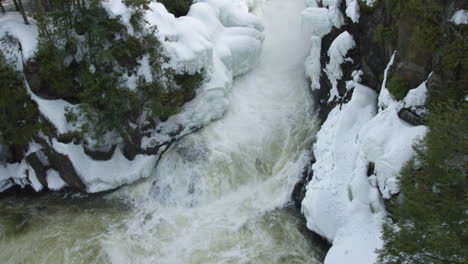 Wunderschönes-Winterwunderland,-Gefrorener-Fluss,-Der-Durch-Einen-Schneebedeckten-Wald-Fließt