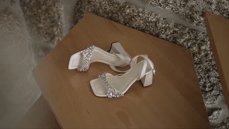 elegant white bridal heels with rhinestone embellishments on a wooden surface, perfect for a wedding day