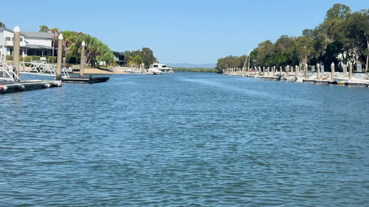 Un campo lungo riprende case di lusso su palafitte e pontili lungo un tranquillo corso d'acqua australiano