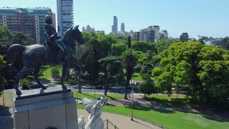 Nahaufnahme-Des-Gehrungsdenkmals-Mit-Grünen-Bäumen-Und-Dem-Blauen-Himmel-Im-Hintergrund,-Buenos-Aires