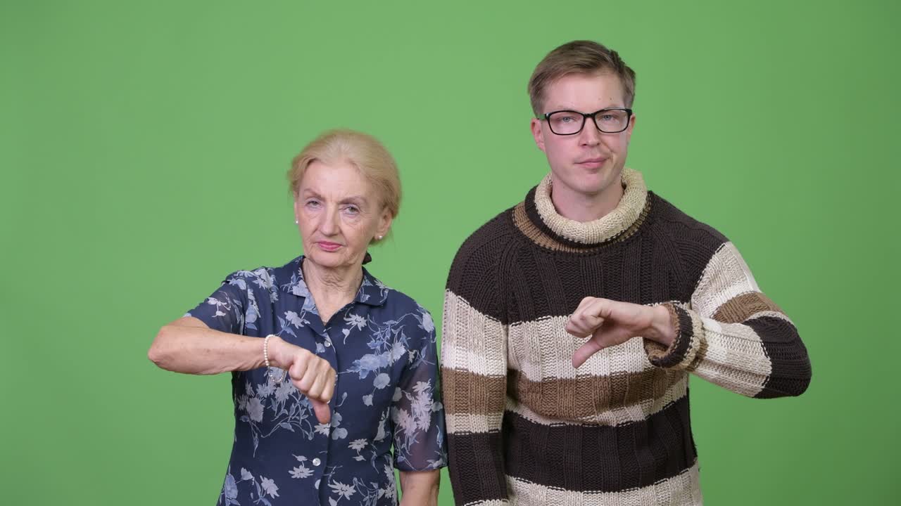 Sad grandmother and grandson giving thumbs down together
