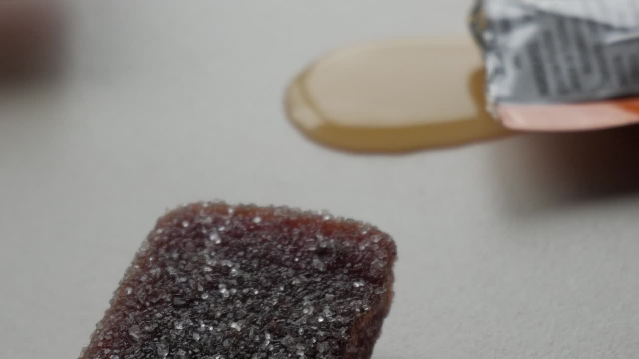 Gummy sports supplement candy, close-up with sugar crystals and syrup on a table