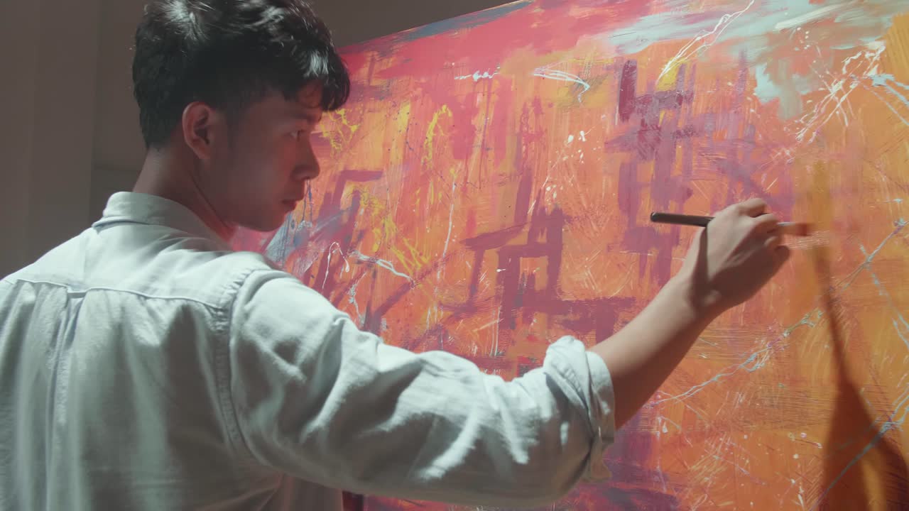Asian Male Artist Working On Abstract Painting, Uses Paint Brush To Create Daringly Emotional Modern Picture