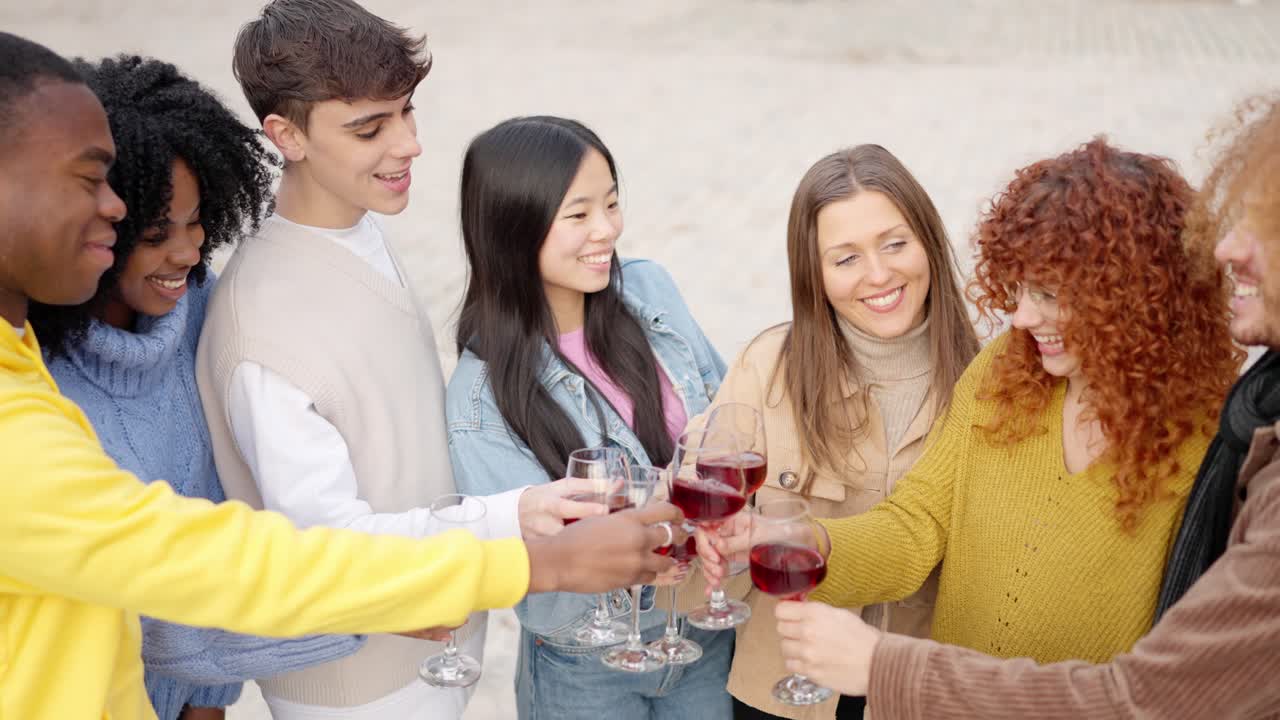 Multicultural young people toasting with wine in the street