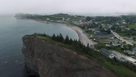 perce rock at the blue water of saint lawrence near the perce town - gaspe peninsula through misty morning in quebec canada